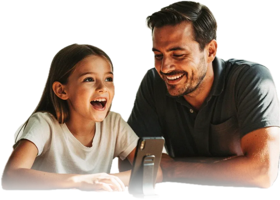 A father and his daughter at a dining table, the girl speaking toward a phone propped on a stand while he sits beside her, watching her rather than the screen